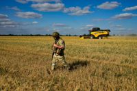 En rysk soldat på en ukrainsk åker. Bilden tagen den 14 juli i år, på en rundtur arrangerad av det ryska försvarsdepartementet.