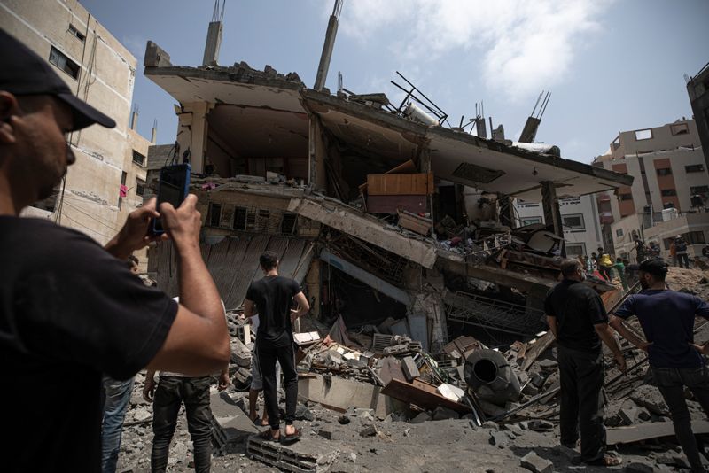 Palestinier inspekterar ett bostadshus i Gaza som skadats i en israelisk flygattack.