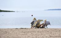 Det är ovanligt varmt för årstiden just nu, både på dagen och natten. Den som har möjlighet kan svalka sig på stranden, som de här personerna på Drumsö i Helsingfors.