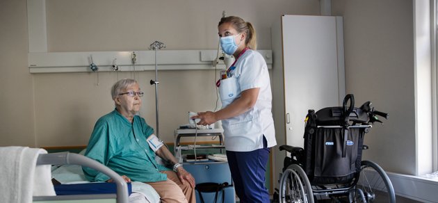 Anja Raatikainen blir omskött av sjukskötaren Linda Estlander på Raseborgs sjukhus komboavdelning.