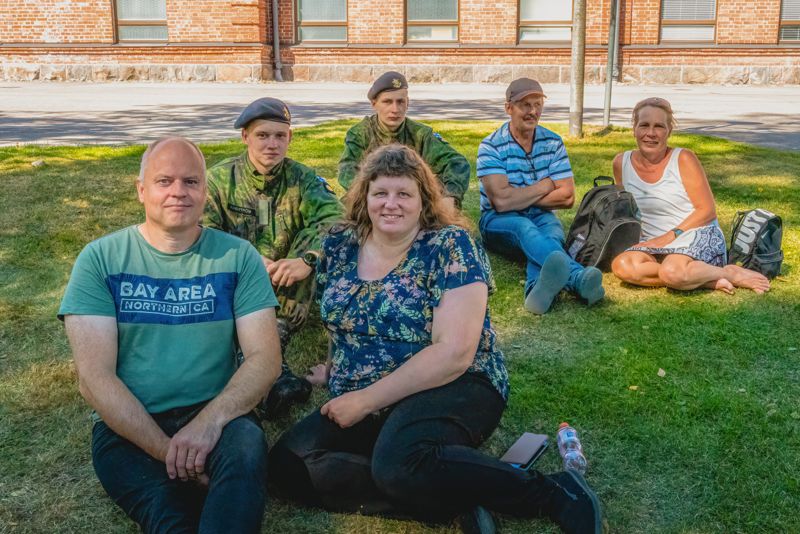 Familjen Sundström och familjen Hjulfors njuter av skuggan. Båda beväringarna tillhör 1. kustjägarkompaniet.