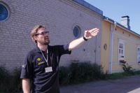Brandinspektör Rasmus Fredriksson förklarar varför det är viktigt att resa brandmurar på vissa ställen. Tegelbyggnaden bakom honom fungerar i sig som en brandmur mot trähuset intill men också mot huset på andra sidan av den smala Bastugatan i Gamla stan i Ekenäs.