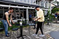 Restaurangchef Jami Lågas och servitör Annas Rahali ställer i ordning bord och stolar utanför hotell Pariisin Ville. Här ska restaurang Meat Districts Smaku-portioner serveras.