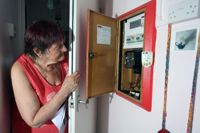 Pensionären Diane Skidmore i London studerar sin smarta elmätare, efter att el- och gaspriserna i Storbritannien har ökat med 80 procent.