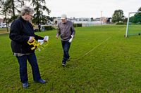Tarja Koski och Paavo Aronen mäter upp gräsplanen i Ånäs. På den ska sju utställningsringar få plats.