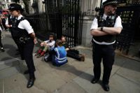 Aktivister genomför en klimatprotest vid det brittiska parlamentet. Här har två personer låst fast sig vid en grind utanför.