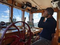 Skepparen Ted Lönnroos håller ett öga på farleden medan han är i ständig kontakt med sjötrafikcentralen.