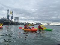 Aktivisterna från Greenpeace Norden paddlar i kajak utanför lastkajen i Nynäshamn. De har lyckats förhindra fartyget Coral Energy från att ta iland och lossa sin last av rysk LNG-gas.