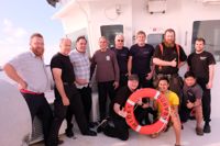 Kapten Timo Väänänen (till vänster) med sin besättning och de räddade seglarna på Midas däck. De räddade seglarna är fjärde, femte och sjätte stående från vänster.