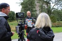 Producenten och kameramannen Reiner Nagel och regissören Britta Wulf ställer in kameran då Sture Lindholm ska intervjuas vid Raseborgs slott.