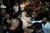 Människor sörjer två av de åtminstone 86 dödsoffren från en förlisning i östra Medelhavet. Bilden togs i Tripoli i norra Libanon på fredagen.