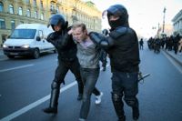 Ryska kravallpoliser för i väg en demonstrant i S:t Petersburg på lördagen.