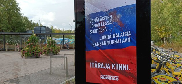 På reklampelarna står ”Medan ryssarna semestrar i Finland pågår ett folkmord av ukrainare. Stäng östgränsen.” undertecknat Sannfinländska ungdomsförbundet.
