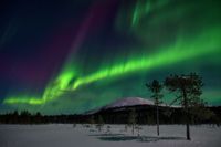 Norrsken fladdrar i fjällandskapet ovanför Äkäslompolo, på lördagskvällen den 15 januari 2022.