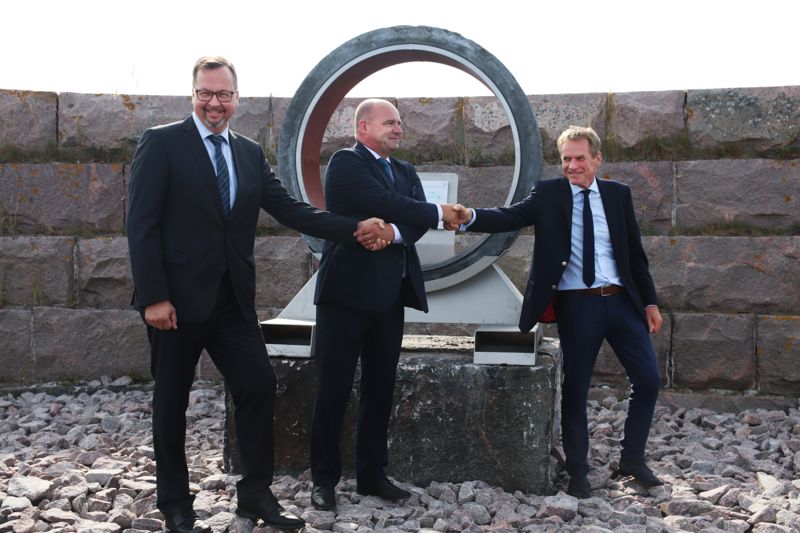 Coating and logistics manager Gunther Blitz från Nord Stream 2, Hangö hamns vd Anders Ahlvik och tillståndschef Simon Bonnell från Nord Stream 2 skakade hand när de avtäckte ett monument om Nord Stream 2-projektet i augusti 2019.