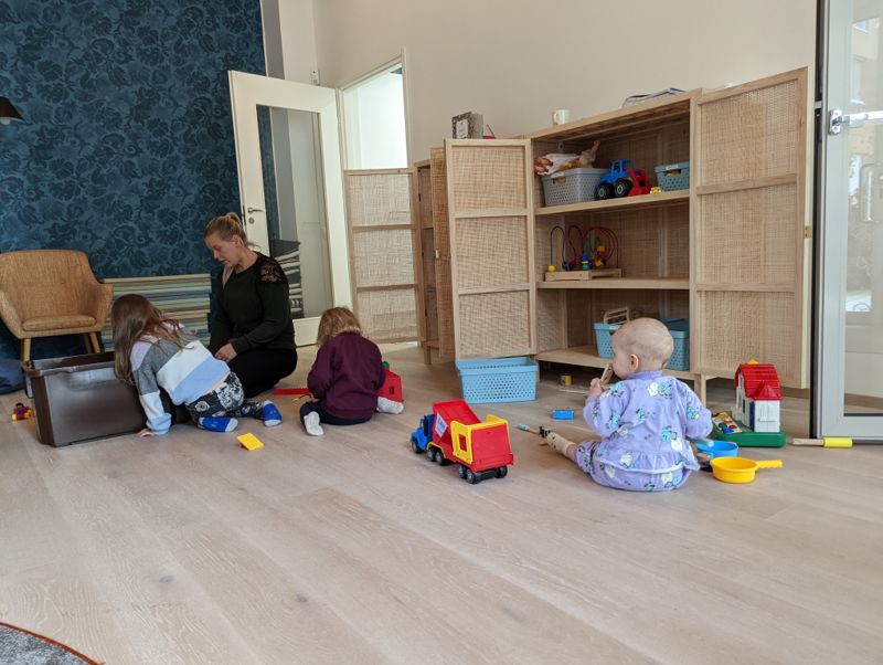 Det finns massor av roliga leksaker som roar barnen, säger Emilia Salo med barnen MInea och Matteo. Elli Mäkelä tittar på.