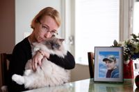 Solveig kramar en av sina katter. På bordet står en bild på Remy.