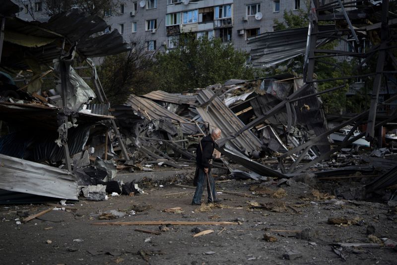 En äldre man går förbi en butik som förstörts i en rysk attack mot Zaporizjzja den 11 oktober.