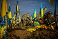 Ukrainsk militär på en kyrkogård i Kiev hedrar en fallen soldat.