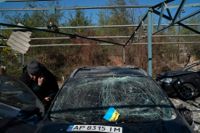 En man inspekterar skadorna på sin bil efter en rysk attack mot Zaporizjzja den 15 oktober.