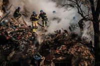 Ukrainska brandmän vid en förstörd byggnad efter en drönarattack mot Kiev tidigare i oktober.