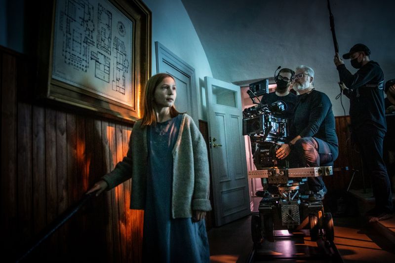 Salma Sarkola agerar framför kamerorna i korridorerna på Svidja slott i Sjundeå. Byggnaden spelar rollen som Hallonbackens kusliga sanatorium i tv-serien som har premiär i slutet av 2023.