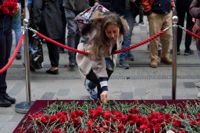 En kvinna lämnar en blomma vid en minnesplats som upprättats på gågatan Istiklal i centrala Istanbul dagen efter dådet.