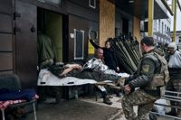 Ukrainska soldater bär en sårad kamrat in i sjukhuset i Bakhmut i Donetskregionen.