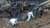 Experter går igenom platsen i östra Polen där en robot slog ned och dödade två människor i tisdags.