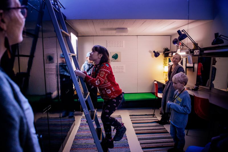 Skådespelaren Sanna Majuri (i bakgrunden till höger) visade sin loge. Barnen fick klättra upp för stegen för att ta en titt på sängen som finns på ovanligt hög höjd.