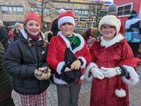 Tomtenissarna Lilli Rajamäki, Onni Wahlqvist och Ella Stenström delade ut karameller.