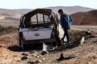 En ung man studerar en bil som träffats av turkiska anfall vid byn Taql Baql i provinsen al-Hasakah, Syrien.
