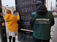 Greenpeace utanför Forum. Miljöaktivisterna föredrar att deras ansikten inte syns på bild. ”Plånboken räcker till, räcker naturen?”, står de på plakaten.