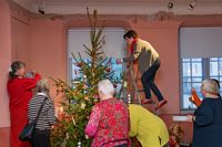 JULSTÄMNING. Margaretha Weckström siktar på grantoppen – nu ska stjärnan sättas på plats i museets julgran.