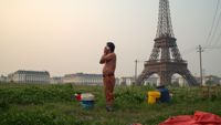 En man i Kina vid en av de över femtio kopiorna av Eiffeltornet som det uppskattas finnas i världen.