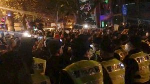 Protester i Shanghai på lördagen. Bilden är en stillbild från en filmupptagning.