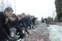 ANDAKT. Hedersvakten i Liljendal lägger ner granriskransar vid hjältegravarna. Kransarna tillverkades av eleverna på Lovisanejdens högstadium.