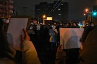 Tomma A4-papper hölls upp vid en demonstration mot covidrestriktionerna i Kina, i huvudstaden Peking i söndags.