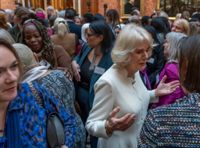 Bild från välgörenhetstillställningen på Buckingham Palace. Drottninggemål Camilla i vitt i förgrunden, med Ngozi Fulani, i brun tröja, snett bakom.