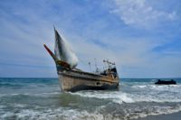 En flyktingbåt som transporterade rohingyer från flyktingläger i Bangladesh ligger vid stranden efter att ha nått indonesiska Aceh på juldagen.