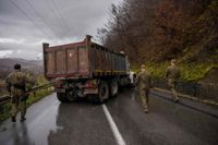 Soldater från KFOR-styrkan inspekterar en serbisk vägspärr i Kosovo.
