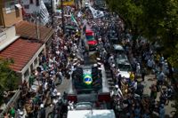 Kistan med Pelé, draperad i Brasiliens och Santos FC:s flaggor, förs i procession till begravningsplatsen i Santos.