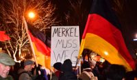 "Merkel måste bort" står det på skylten som en av demonstranterna håller upp.
