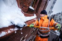 Det är viktigt att röja bort blöt snön innan det fryser till is, säger Mikko Turunen. Här röjer han snö från taket vid Svenska Klubben i Kronohagen. 