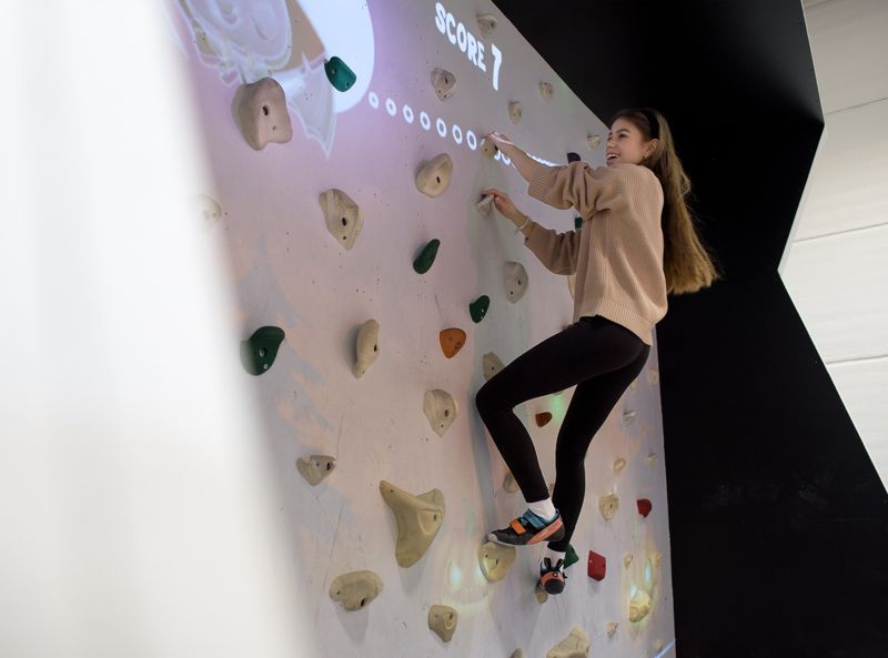 Emilia Lindström lyckas hålla sig på spelväggen i flera minuter. – Det är tungt men roligt att klättra längs väggen och jaga figurer, säger hon.