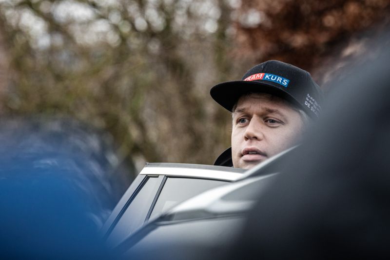 Paludan kikar ut från polisbilen för att se om det är dags för hans ”protest”.