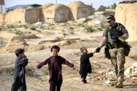 En finländsk ISAD-soldat tillsammans med afghanska barn i Mazar-i-Sharif år 2010.