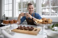 Anders Wikström är en vän av baktraditioner och bakverk förknippade med högtider. På bilden har han bullat upp med Runebergstårtor till vänster, brownies med kaffesmörkräm, tranbär och kolasås, i mitten, och kokostoppar, kolakakor och sockerdoppade bullar till höger.