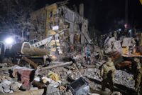 Räddningspersonal söker efter skadade i spillrorna av ett bostadshus i Kramatorsk efter en rysk robotattack.