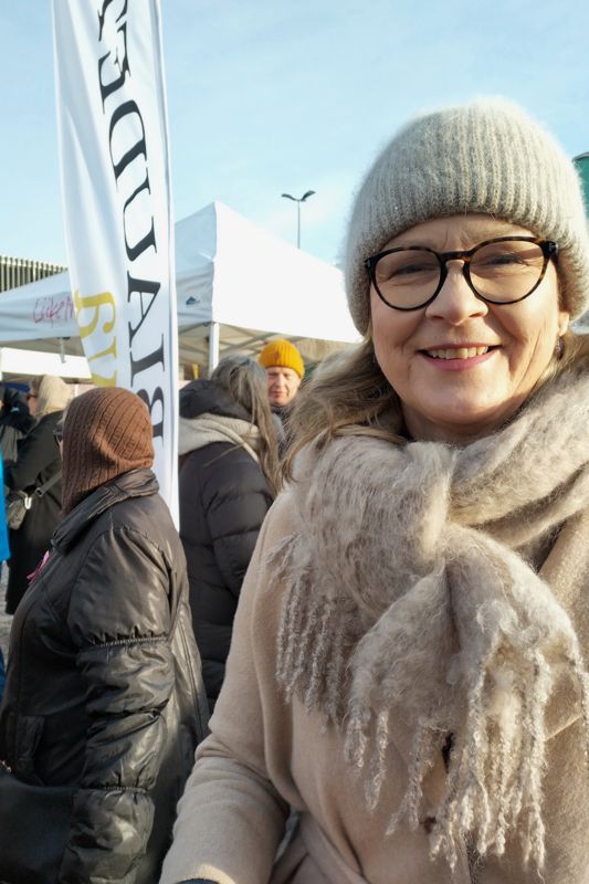 Eva Biaudet njuter av Runebergsdagens lite dämpade solsken på Hagnäs torg. Hon säger att valmarknaden fyller en viktig funktion då folk av pur nyfikenhet kan kliva fram och samtala med politiker och kandidater, oberoende av vem man tänker rösta på.